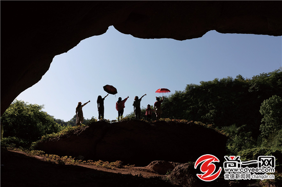 游客在巨大的洞穴入口拍照。