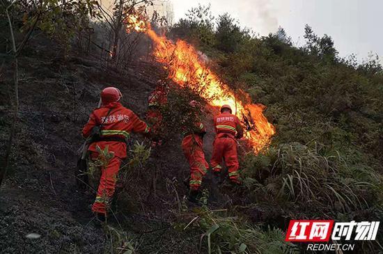 9月26日上午，连续奋战十多个小时的武警官兵正在加紧扑灭山火。