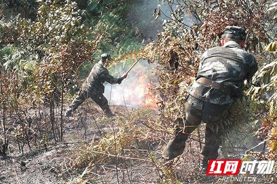 9月25日上午，武警官兵正在扑打明火。