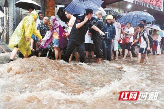 6月29日下午，凤凰县人民医院附近，民警在一处井盖喷涌处执勤，保障市民安全出行。