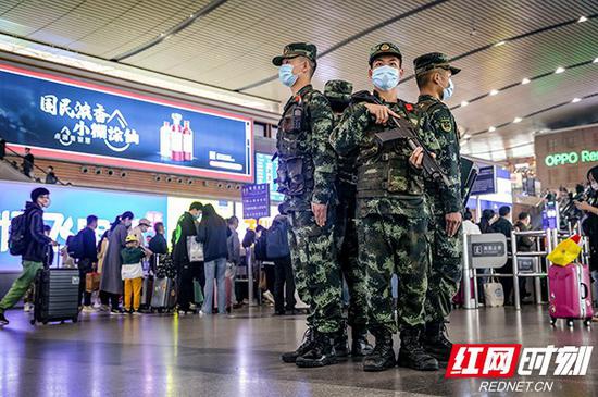 正在长沙火车南站进站口维持秩序的武警官兵。