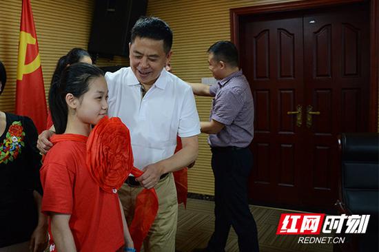 湖南省演艺集团党委书记、董事长吴友云为代表团成员佩戴大红花。