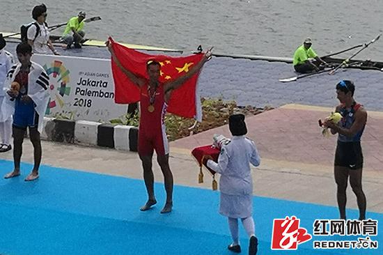 张亮挥舞国旗在亚运会颁奖典礼现场。供图/湖南省体育局水上运动管理中心