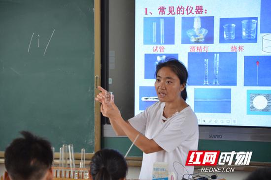 化学课堂上，彭向教学生认识实验室、仪器、药品柜。