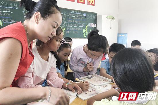 周琴在班上辅导学生学习。