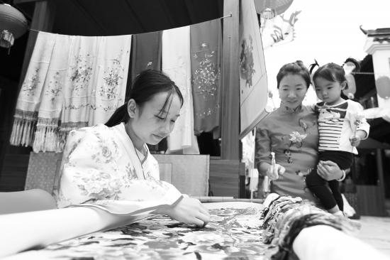 10月1日,铜官窑古镇湖湘非遗文化体验展在铜官窑古镇弘文广场开集,手工艺人正展示湘绣工艺。图/记者金林