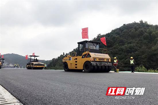 在莲株高速公路施工现场,工人们正紧张有序地进行沥青路面摊铺作业。