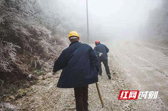 风雪中前行的电力巡线人。