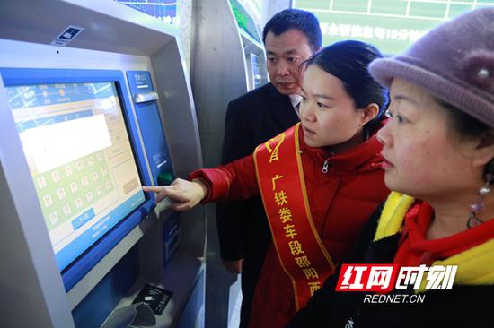 车站服务人员正在协助市民买票。
