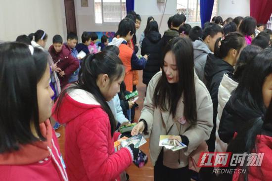 重大优秀志愿者李婧给特殊学生发放手心爱心明信片。