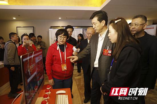 蔡振红看望湖南广播电视台参与报道两会的新闻工作者，观看电视产品。