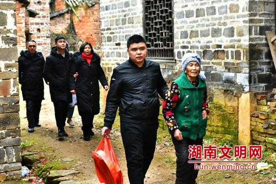 骆勇文带着自己家人回到他成长的蓝山楠市镇环连村。图片来源：湖南文明网