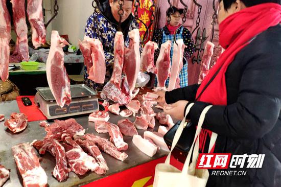 市民在菜市场购买猪肉。