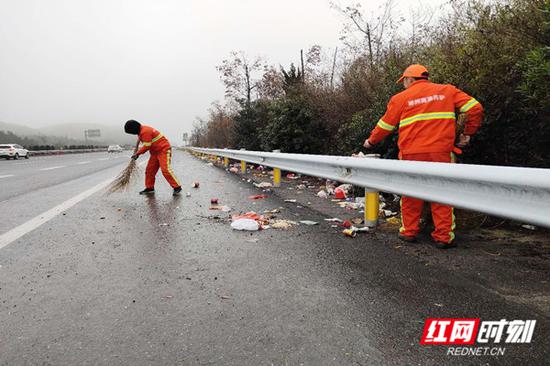 春运期间,许广高速郴州境内,养护工人正常清理路肩上的垃圾。