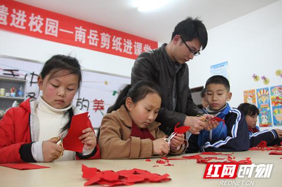 3月13日,在衡阳非遗进校园—南岳区金月完小剪纸课堂上,“南岳剪纸”非遗传承人肖焕手把手教孩?#29992;?#21098;出自己喜爱的花样。