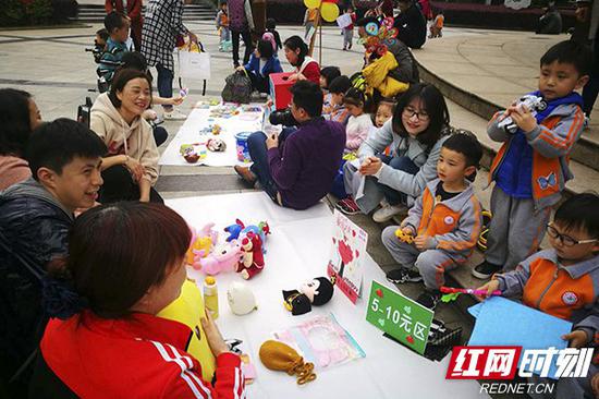 精心布置的摊位上摆满了玩具、图书、配饰、背包、童车等物品。