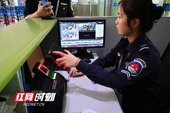 机场安检站验证工作人员正在扫描旅客电子登机牌 。