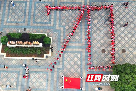 　现场通过人形队伍排出“70”字样。王翟/摄