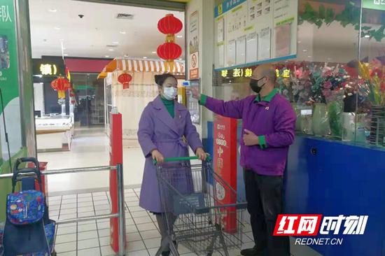 1月30日，长沙城南某大型超市，工作人员对进入超市的顾客进行体温检测。