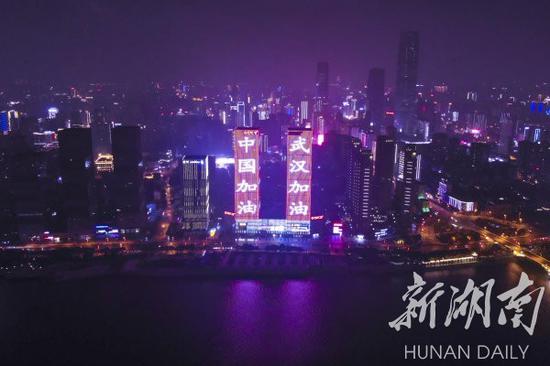 (2月8日,元宵节,长沙市开福区万达广场高楼外墙亮起“武汉加油,中国加油”、“同舟共济,同江同湖”等字样的标语。湖南日报·新湖南客户端记者 辜鹏博 摄)