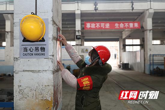2月21日，长沙市开福区，新大塘社区工作人员正在中铁五局三环机械厂厂房内张贴疫情防控宣传海报。