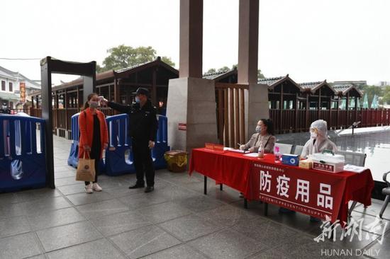 (2月27日,南岳衡山景区恢复开放,工作人员为游客测量体温、登记信息。)