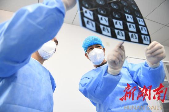 2月23日,湖北省黄冈市英山县人民医院,65岁的李新中仔细查看患者的CT检查结果。湖南日报记者 辜鹏博 朱玉文 摄