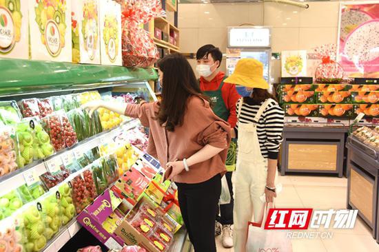 　　新鲜水果上市，市民进店购买。