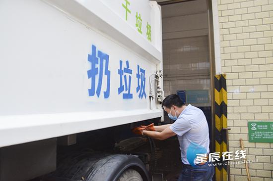 　（芙蓉区市容环境卫生维护中心的队员戴伯钧在马王堆陶瓷城B区装运垃圾。）