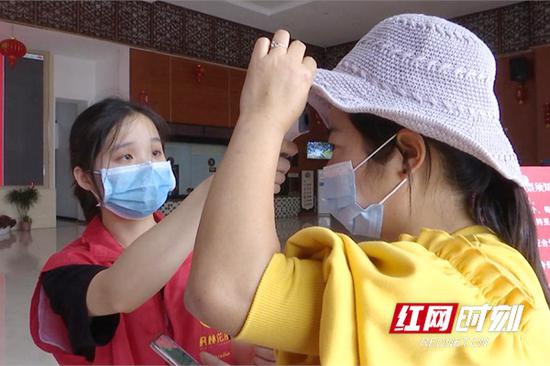 景区内工作人员检查游客体温是否正常。