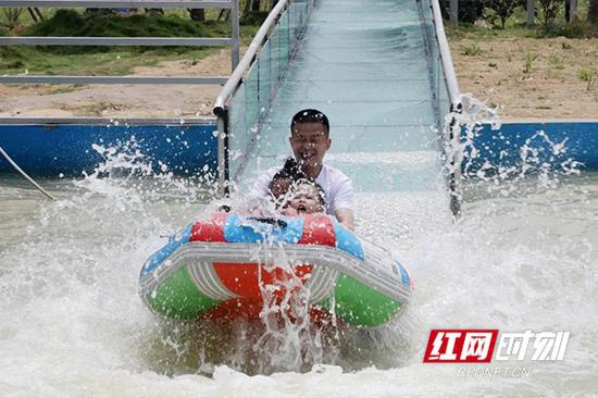 游客正体验着“高空玻璃彩色水滑道”项目。
