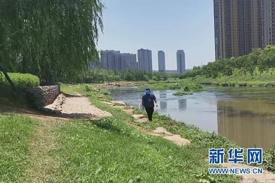 长沙市雨花区圭塘河边,刘常彪正在巡河。