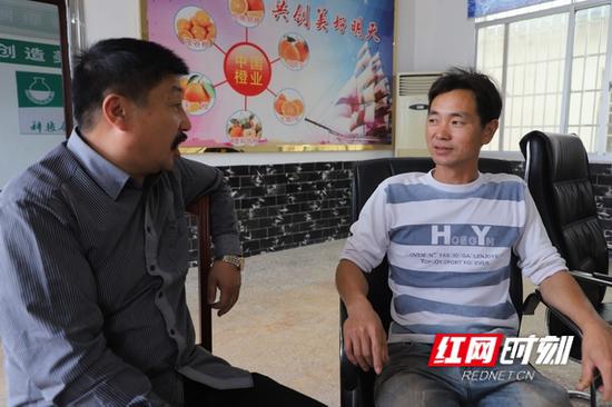 陈名村(右一)向合作社负责人请教果树栽培技术。