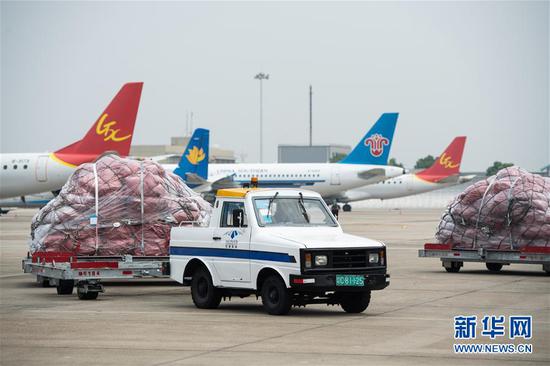 5月28日，在长沙黄花国际机场，货物牵引车把跨境电商包裹拖运到停机坪。
