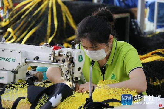 ↑5月22日，在星海运动公司厂房，员工在缝纫体育用网。 新华社发（蔡潇潇 摄）