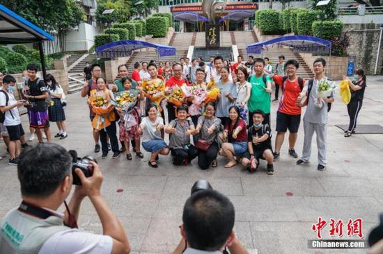 7月8日下午,广西南宁二中新民校区考点,高考英语科目考试结束后,老师与考生在考场外合影留念。 中新社记者 陈冠言 摄