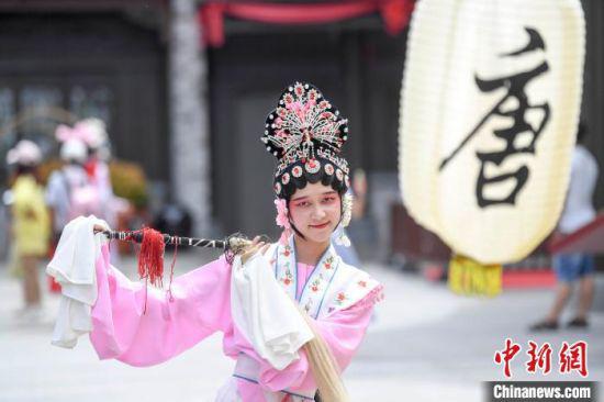 伴随着流行音乐,演员在街头表演京剧。 杨华峰 摄