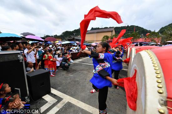 ↑在湖南省湘西土家族苗族自治州花垣县双龙镇岩锣村西瓜节活动现场，苗族群众在打苗鼓。CICPHOTO/龙恩泽 摄