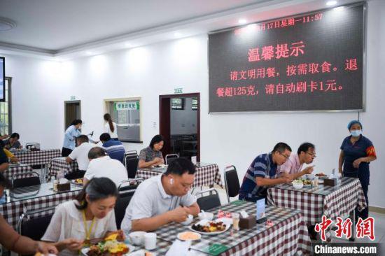  餐厅电子屏上显示退餐罚款的提示。　杨华峰 摄