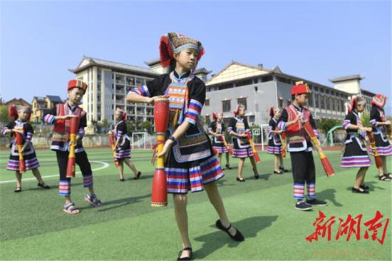 8月30日,江华瑶族自治县水口镇中心小学,李心怡(中)和同学表演瑶族长鼓舞。长鼓舞已成为该校大课间活动的内容。以上图片均为湖南日报·新湖南客户端记者 辜鹏博 摄