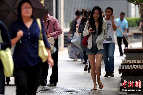 白露PC配图。“白露身不露” ,北京街头行人“混搭装”出行。中新网记者 金硕 摄