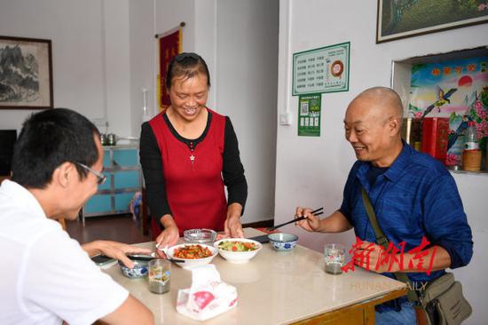 (9月5日,桂东县沤江镇青竹村桃林民宿,老板娘熊桂荣为客人上菜。 湖南日报·华声在线记者 傅聪 摄)