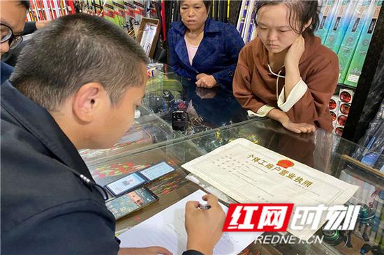 执法人员在现场检查,了解登记商户信息。