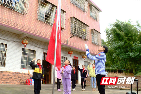 王培相带领孩子们在家门口升国旗。
