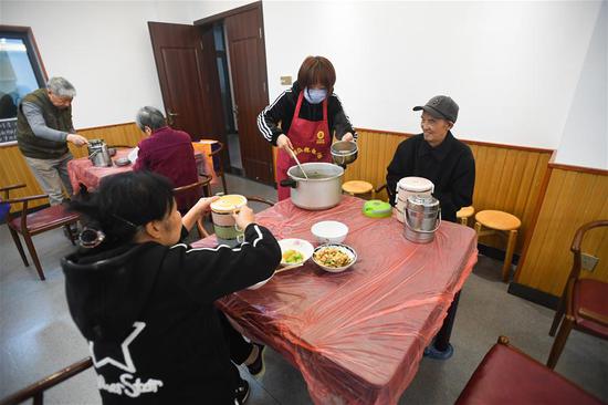 10月21日，在长沙市天心区赤岭路社区文化活动中心，工作人员在午餐时为老人盛汤。新华社记者 陈泽国 摄