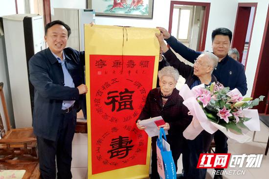 天心区委副书记、区长黄滔(左)一行登门向袁娭毑祝寿