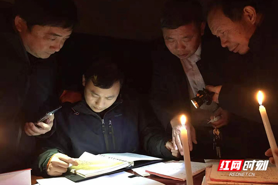 停电的冬夜,工作人员借着烛光在金江镇罗家村连夜调研。