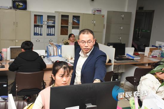 (张西军和同事交流工作。星辰全媒体记者 黄超 摄)