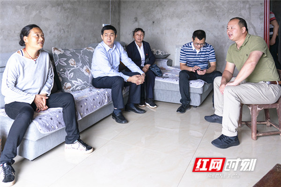 全国人大代表，国家开发银行湖南省分行党委书记、行长袁建良（左二）与农户交谈。