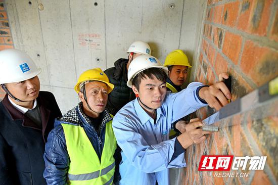 中国建筑五局总承包公司质量管理员邹彬。(前右一)